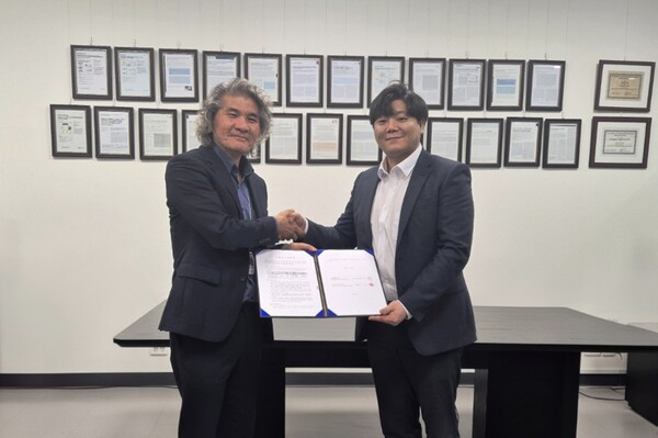 Representatives shaking hands while holding the antiviral technology transfer agreement